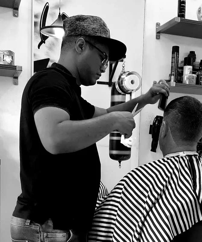 Barbero de Barbería 84 trabajando con tijera y peine