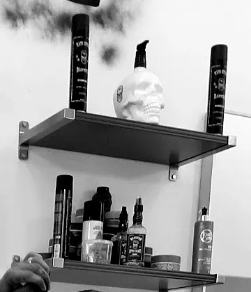 Estante con productos de barbería y una calavera decorativa