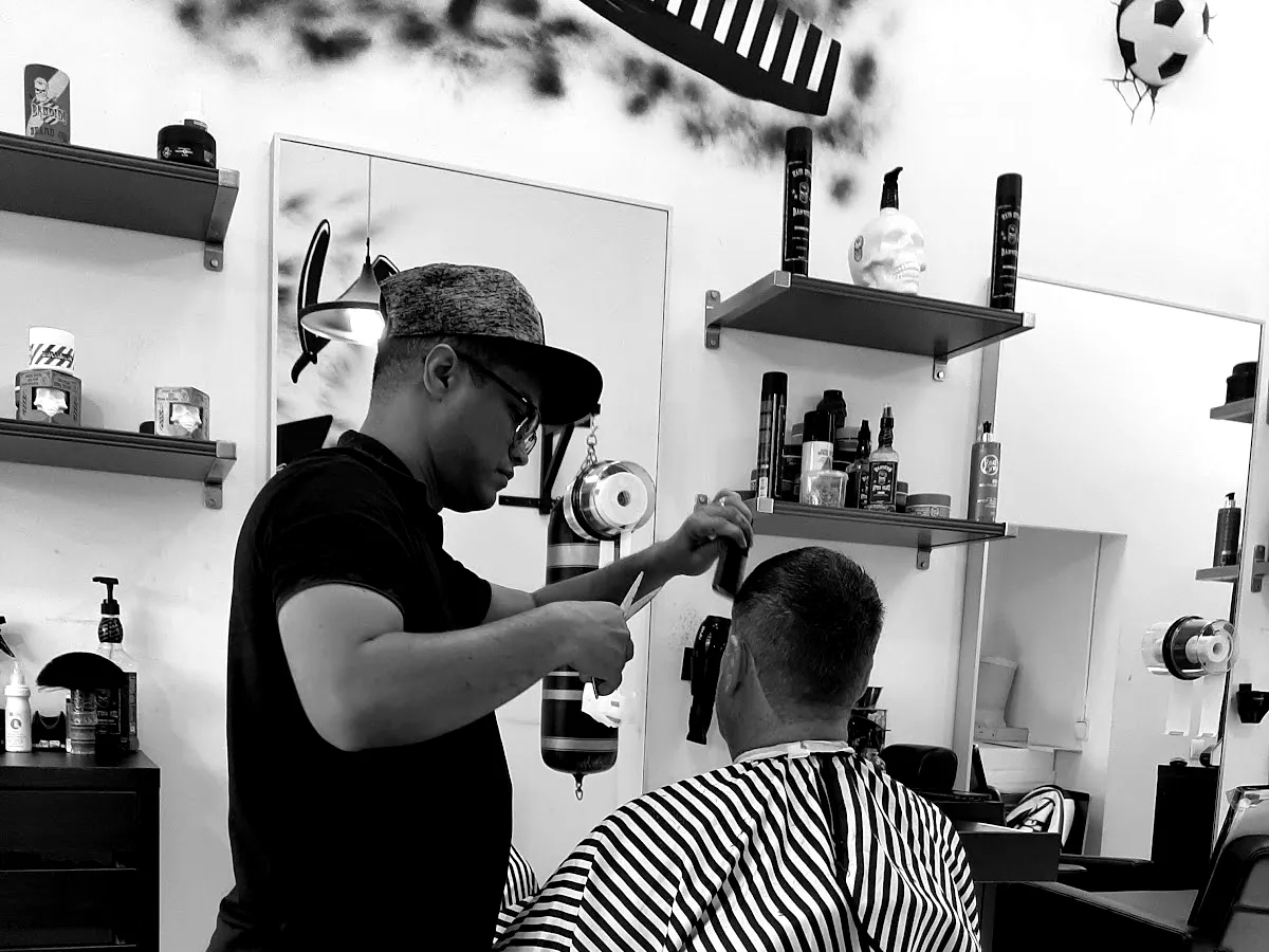 Interior de Barbería 84 con grafiti en la pared y estantes de productos